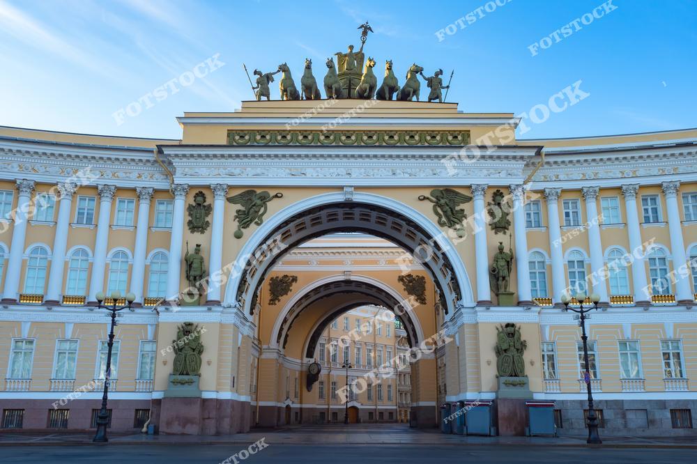 На фотографии изображена арка Главного штаба на Дворцовой площади в Санкт-Петербурге. Эта величественная арка, увенчанная скульптурной композицией с шестёркой лошадей, является символом победы в Отечественной войне 1812 года. Она соединяет два крыла здания Главного штаба, которое было построено по проекту Карла Росси. Пространство арки оформлено в стиле ампир с изысканным декором и скульптурами. Это одно из самых узнаваемых мест в центре Санкт-Петербурга.